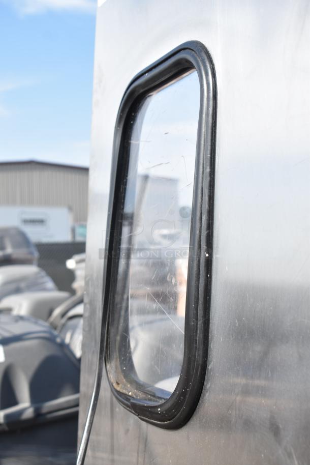 Eliason stainless steel swinging kitchen door with window and hardware, industrial-grade, minor scratches visible.