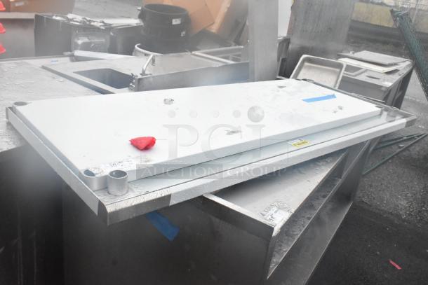 Brand new tabletop and under shelf, stainless steel, scratch and dent condition, protective wrap, labels indicating manufacturer details.