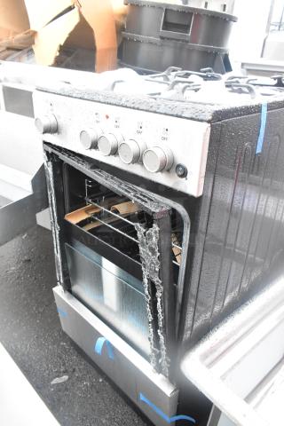 4 burner range with oven, visible oven door damage, metal knobs, exterior wear, located outdoors.