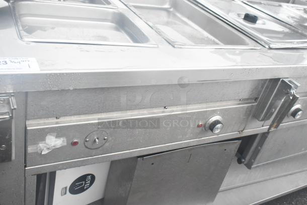 Dinex DHF6 steam table with over and under shelves. Stainless steel, used condition, 208 volts, visible control knobs and dish compartments.