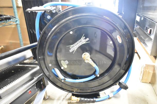 Brand new Regency powder-coated steel air/water hose reel, with visible minor scratches and dents, blue rubber hose included.