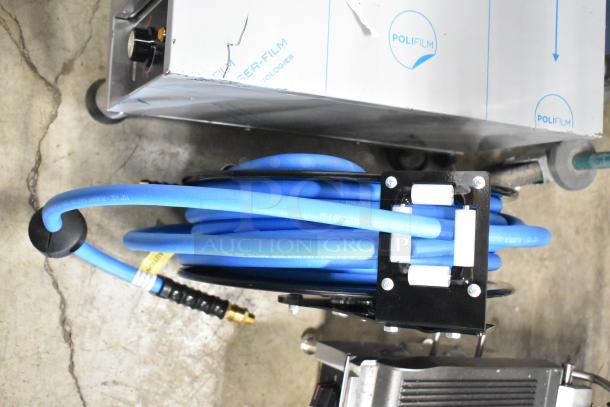 BRAND NEW SCRATCH AND DENT Regency steel hose reel with blue hose, powder-coated, durable air/water use, visible signs of wear.