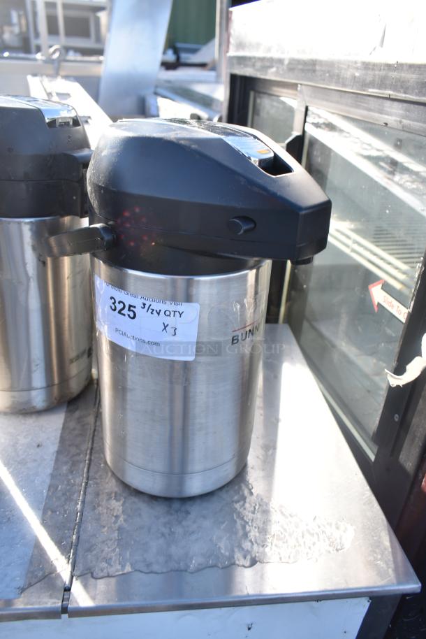 Three stainless steel Bunn countertop air pots with black lids, in good condition. Label indicates quantity X3 for auction.