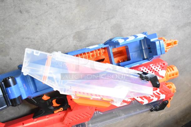 Two Nerf Rival toy guns, one blue and one red, with clear ammo chambers, in good condition.