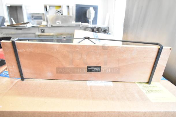 Wooden stand with black metal brackets, rectangular shape, visible label reading "ATOS 35820." Placed on a cardboard box.