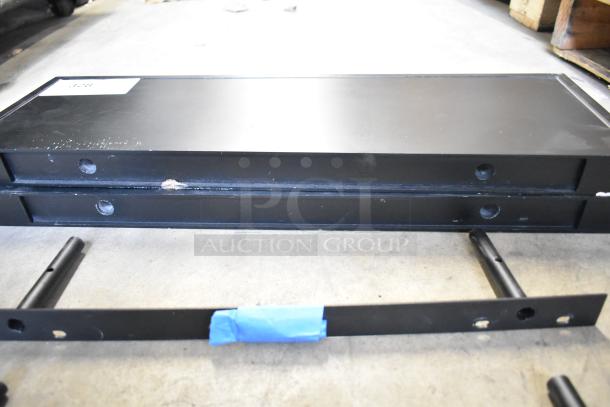 Black metal shelves, 2 pieces, some wear visible. Includes mounting bars. Marks indicate previous use and handling.