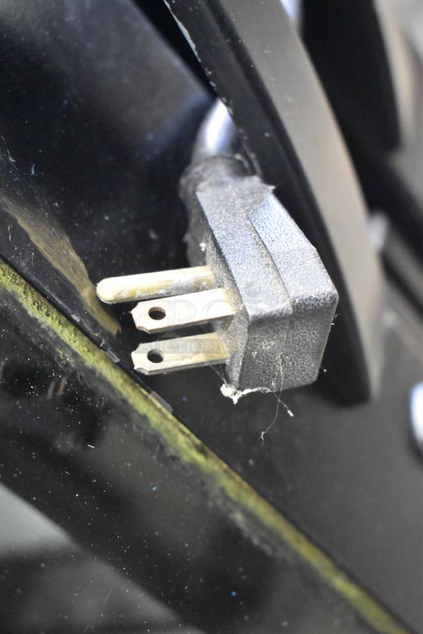 Close-up of a power plug from a 2017 True STG2RPTVLD-2G-2S-HC commercial cooler, showing prongs and cable wear.
