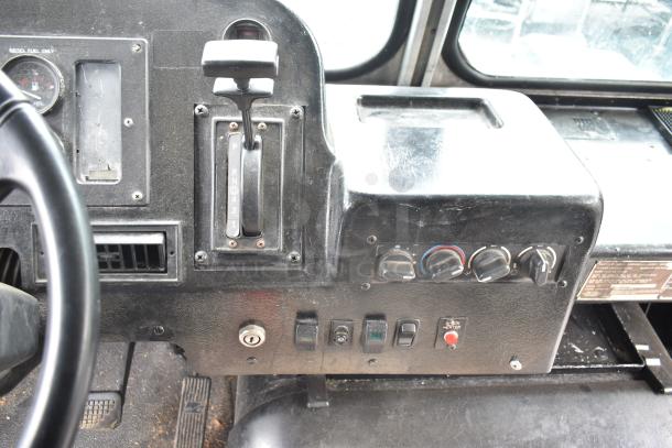 Freightliner food truck dashboard with gear shift, control dials, and switches. Shows vintage interior condition.