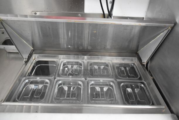 Stainless steel food compartment in a 2002 Freightliner food truck, featuring multiple removable trays for storage and organization.