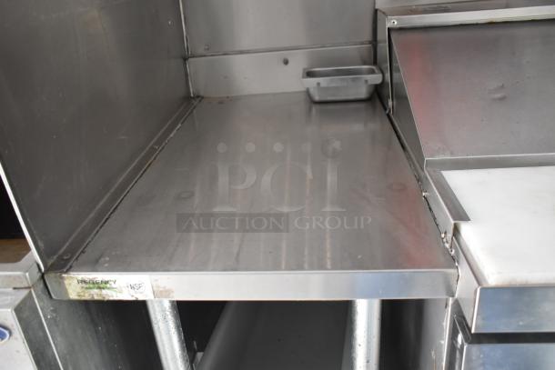 2002 Freightliner food truck interior showing stainless steel countertop and grease hood, part of cooking area setup.