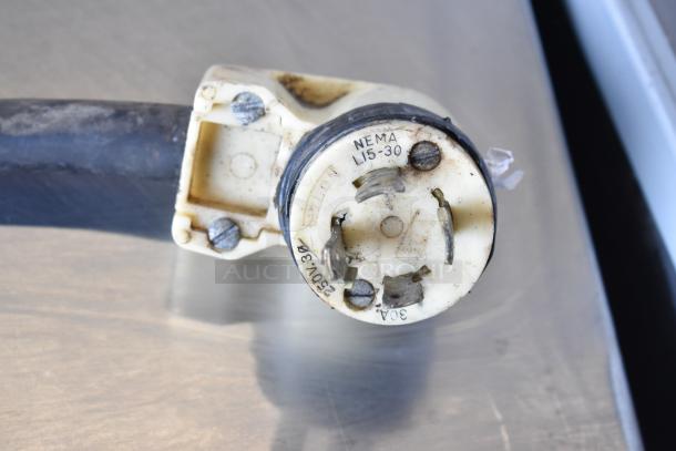 Close-up of a NEMA L15-30 plug on a Taylor S757-33 soft serve machine, indicating 208-230 volts, 3-phase power.