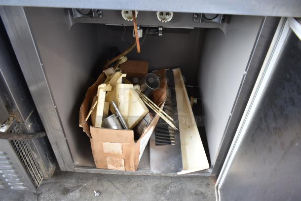 Taylor S757-33 ice cream machine parts, including various internal components and accessories stored in an open compartment.