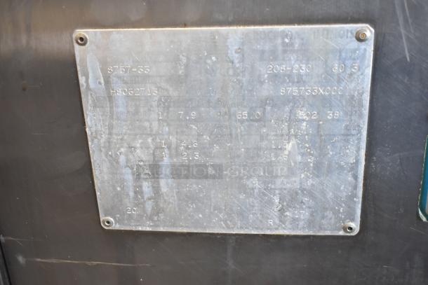 Taylor S757-33 soft serve machine label showing model, 208-230V, 3 phase. Used condition, metal finish with visible wear.