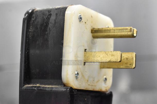 Close-up of an electrical plug connector for the Thermoplan Mastrena II CS espresso machine, showing brass prongs and plastic base.