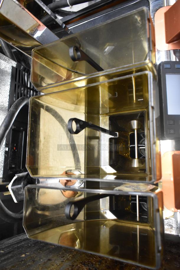 Thermoplan Mastrena II CS espresso machine interior, showing coffee bean hoppers and stainless steel components.