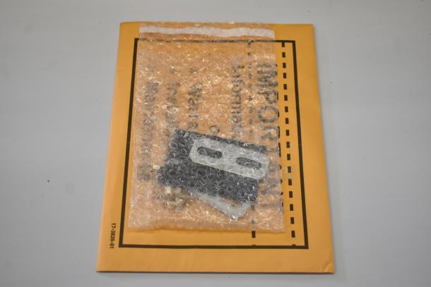 A Scotsman MC0330MAX-1A ice machine part in bubble wrap on a yellow labeled envelope, indicating a new condition.