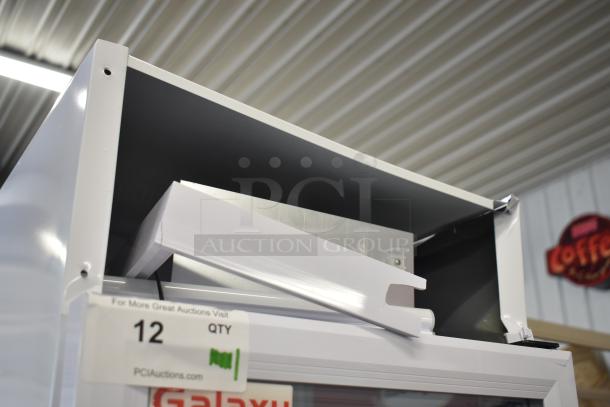 Brand new Galaxy 177GDN5RBW merchandiser fridge, scratch and dent condition. White swing glass door, LED lighting, 115V. Auction tag visible.