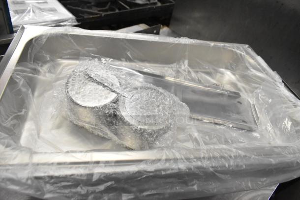 18 new scratch and dent items including chafing dish frames and drop-in bins. Packaged with protective wrap.