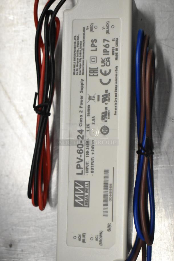 Mean Well LPV-60-24 power supply, scratch-and-dent, inputs 100-240V, outputs 24V, new condition, visible label and wiring.