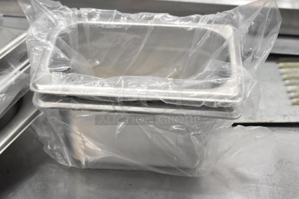 Two stainless steel drop-in bins, condition: scratch and dent, partially wrapped in plastic, suitable for kitchen use.