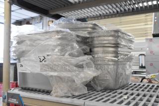 21 brand new scratch and dent drop-in bins, various sizes, wrapped in plastic, on a metal shelf.