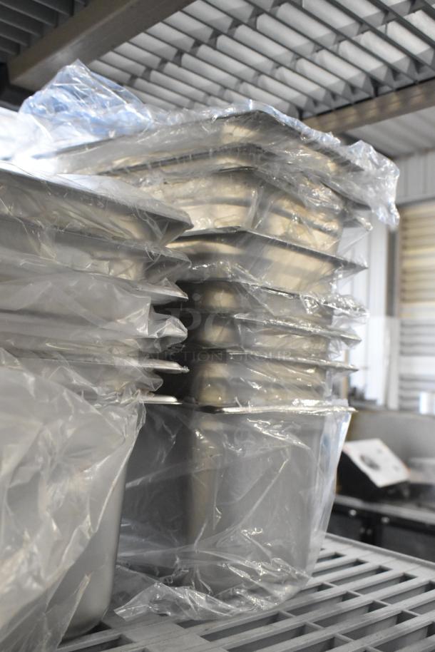 21 brand new scratch and dent drop-in bins, wrapped in plastic, stacked on a metal shelf.