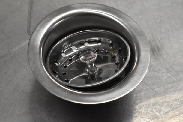 Stainless steel sink strainer with removable center, new condition, part of a scratch and dent auction lot.