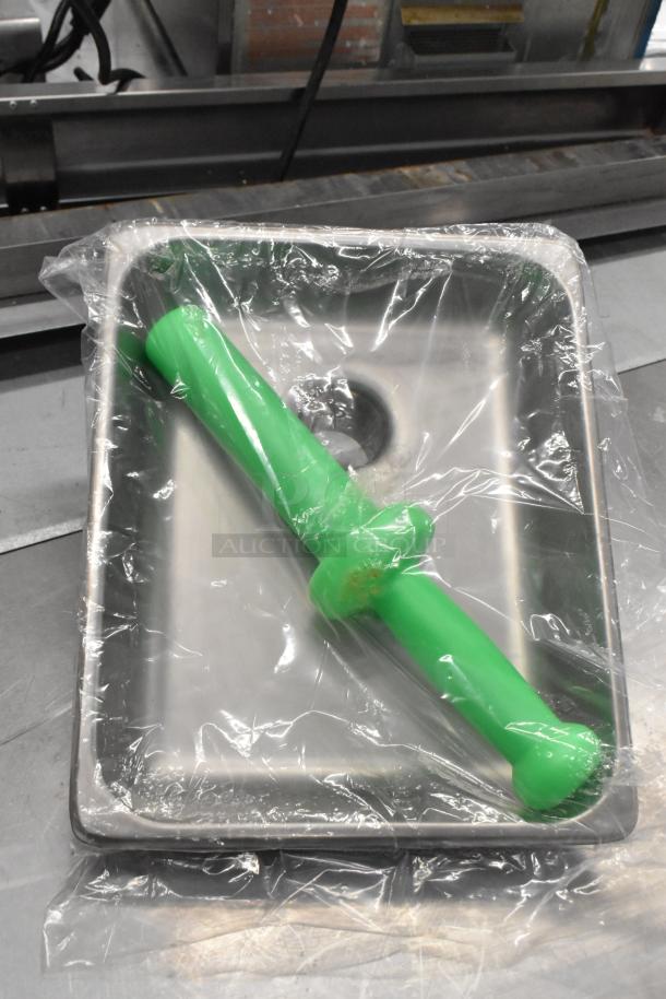 Brand new scratch and dent meat grinder attachment with auger, stainless steel tray, and green pusher, wrapped in plastic.