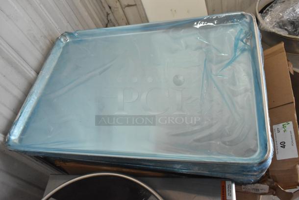 Brand new full-size 18" x 26" aluminum bun pan; 19 gauge, scratch and dent, protective wrap visible, stack of pans.