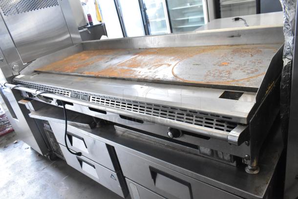 American Range commercial countertop flat top griddle with four-drawer chef base, visible wear and rust on surface.