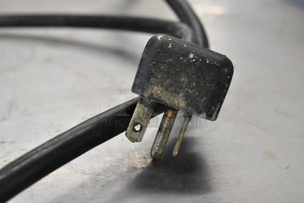 Close-up of a worn power plug from a Panasonic NE-21521 Commercial Microwave, showing signs of use.