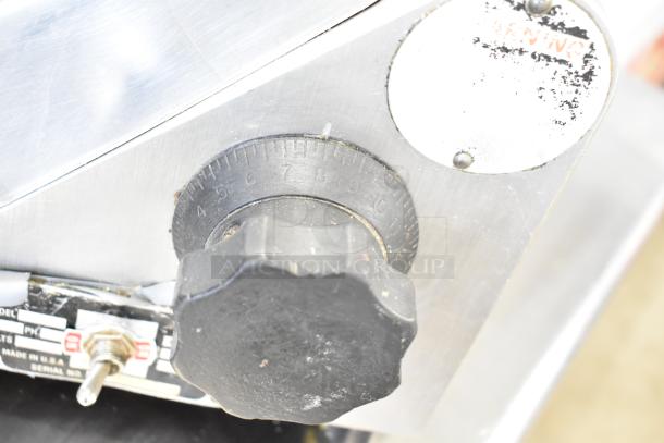 Globe Commercial Countertop Meat Slicer with Blade Sharpener, 115 Volts, 1 Phase, showing control knob and worn warning label.