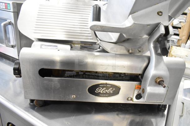 Globe commercial countertop meat slicer with built-in blade sharpener. Stainless steel, used condition, 115 volts, 1 phase.
