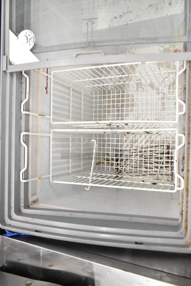AHT RIO S 125 Commercial Freezer with wire shelves, used condition. Model and voltage labels visible on the interior.