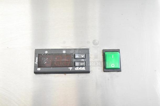Control panel of Arctic Air AR23E commercial cooler with Dixell display and green power switch.