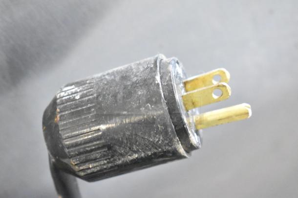Close-up of a power plug from an Arctic Air AR23E commercial cooler, showing signs of wear.