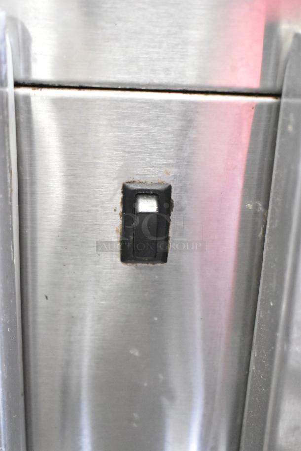 Commercial 3 Door Undercounter Cooler in stainless steel, power switch detail, on commercial casters. 115V, 1 phase.