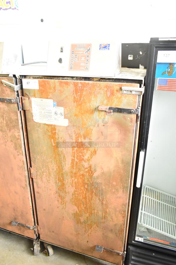 Cookshack 250 commercial electric smoker, 208V, 1 phase, worn exterior, commercial casters, visible control panel and labels.