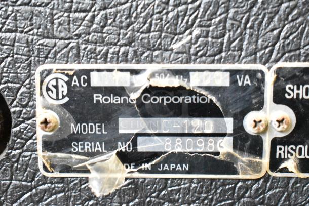 Label on Roland Jazz Chorus JC-120 speaker, showing model and serial number, with visible wear and texture.