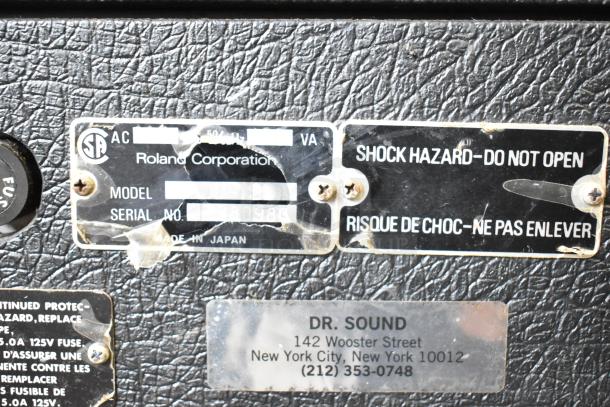 Roland Jazz Chorus 120 Speaker label showing model and serial number. Made in Japan. Warning and store label visible.