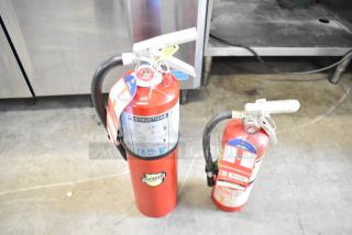 Two fire extinguishers, including a Buckeye model, red with instruction labels. Buyer pick-up only; not for shipping.