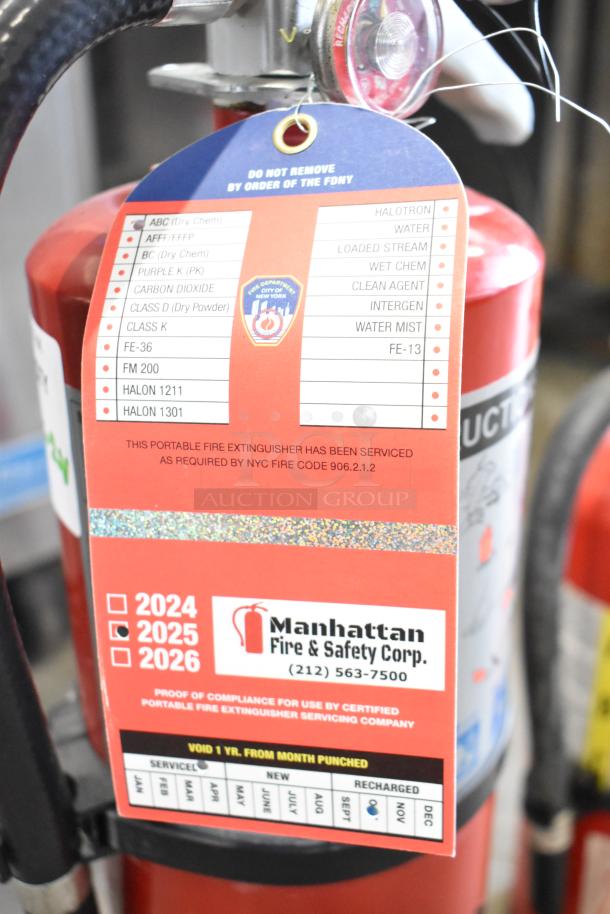 Two fire extinguishers, including Buckeye brand, with service tag by Manhattan Fire & Safety Corp, meets NYC code 906.2.1.2.