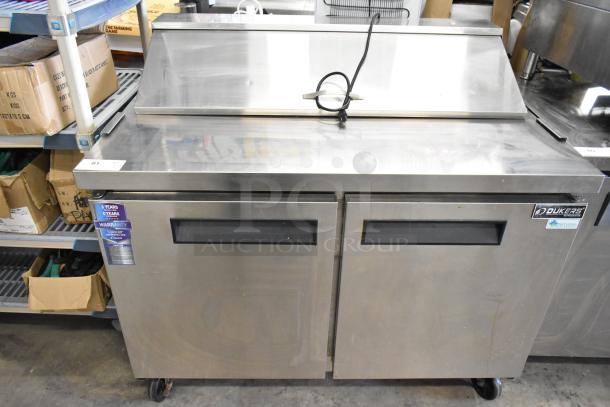 Dukers DSP48 Sandwich Salad Prep Table, stainless steel, commercial casters, warranty tag, runs on 115 volts, 1 phase.