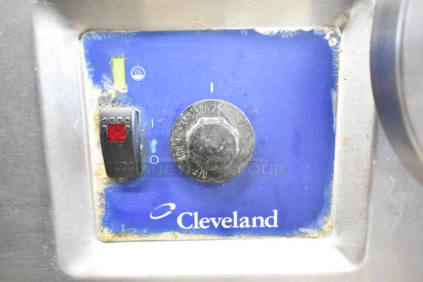 Cleveland commercial braising pan control panel with temperature dial and switch, showing wear. Cleveland logo visible.