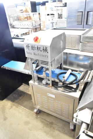 Seny Machinery commercial slicer and conveyor on casters. Stainless steel, 220V, sturdy design, labeled in English and another language.