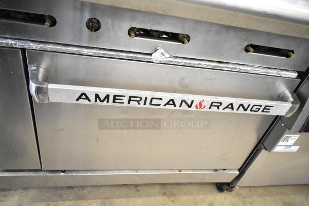 American Range commercial gas-powered 6-burner range with oven, over shelf, and backsplash. Features visible wear.