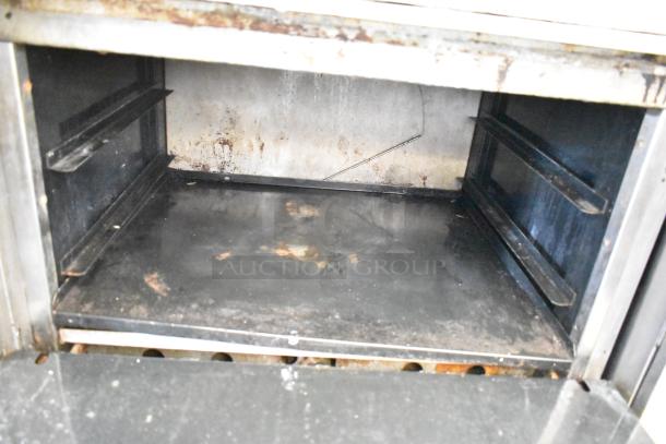 American Range commercial gas-powered 6 burner oven interior, shows some wear, includes overshelf and backsplash.