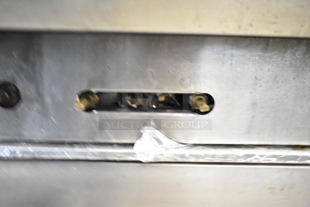 Close-up view of a stainless steel component on an American Range commercial gas-powered 6 burner range.