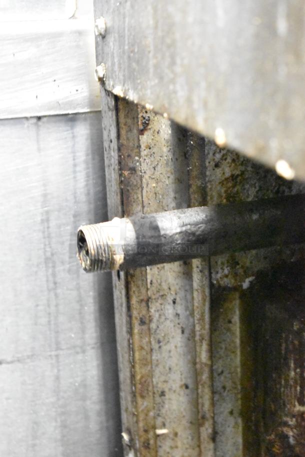 Close-up of a gas pipe connection on an American Range commercial 6 burner stove, showing signs of wear and rust.