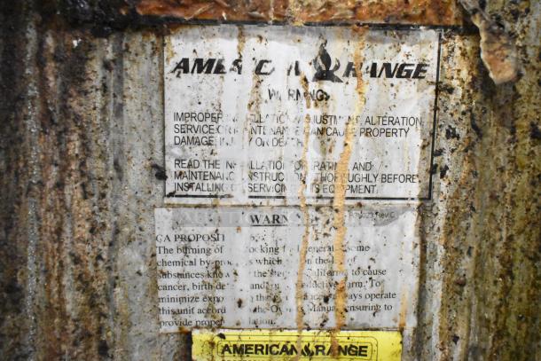 American Range commercial gas 6 burner range. Visible labels warn of improper installation. Signs of wear and rust.